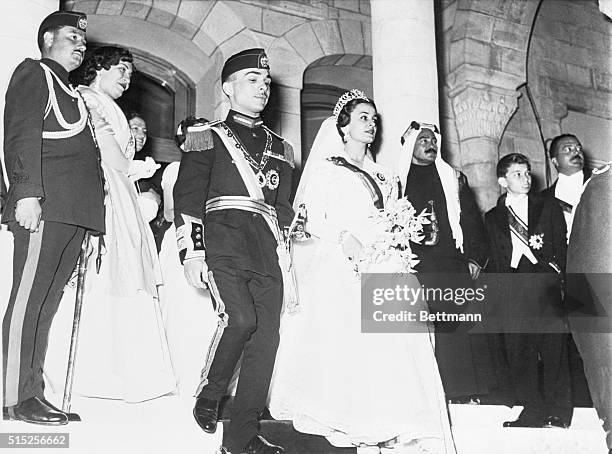 Photo shows Hussein Ibn Talal, King of Jordan holding the hand of his first bride, Princess Dina, daughter of Prince Abdel-Hamin Aoun of Hijaz,...