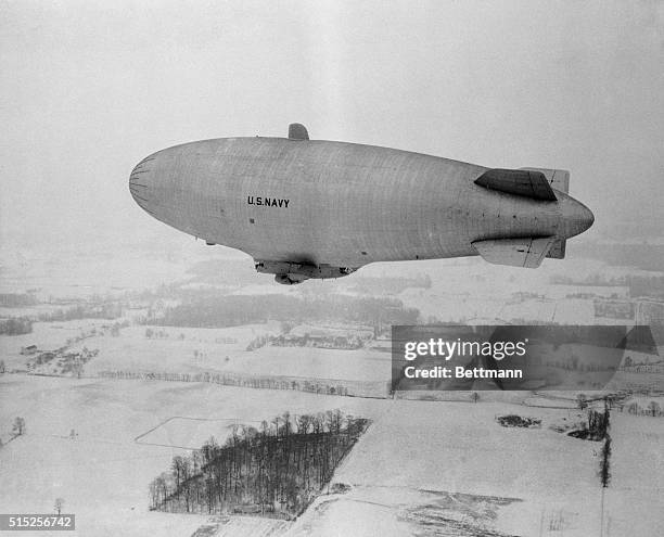 The U.S. Navy's newest blimp, the Goodyear ZPG-2W, shone on its first test hop at Akron, Ohio, passes over snow-covered fields. The Goodyear Aircraft...