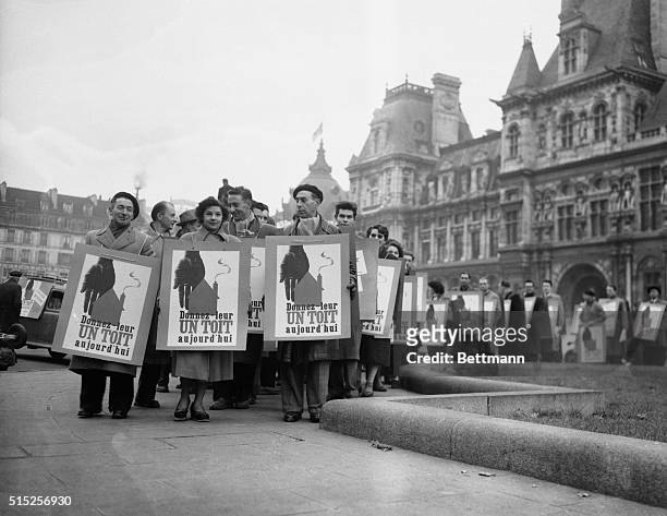 Placarded Parisians gather in front of the city hall before marching through the streets of the French capital in a campaign to obtain housing for...
