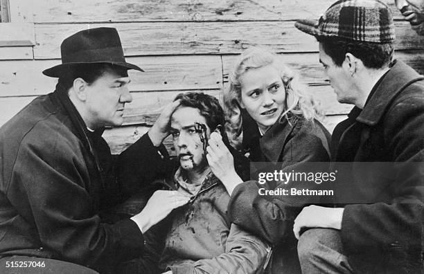 Father Barry realizes that Terry will be all right after a brutal beating by one racketeer waterfront boss as Edie stands by in the 1954 motion...