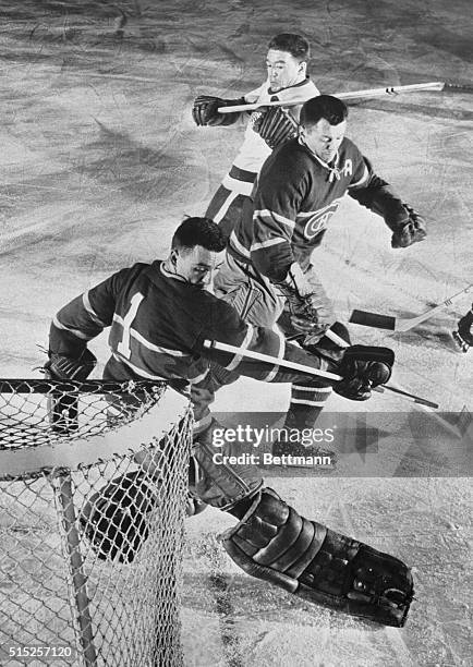 Montreal Canadiens goalie Jacques Plante looks over his shoulder to discover the shot by Marcel Pronovost of the Detroit Red Wings is in the net for...