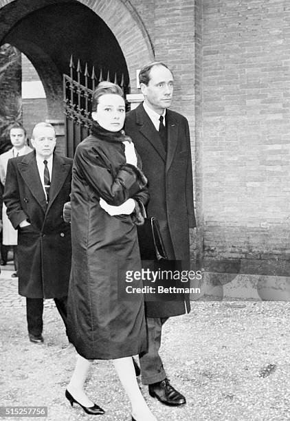 Actress Audrey Hepburn and her actor husband Mel Ferrer leave the chapel of the English cemetery in Rome, after attending the funeral service of...