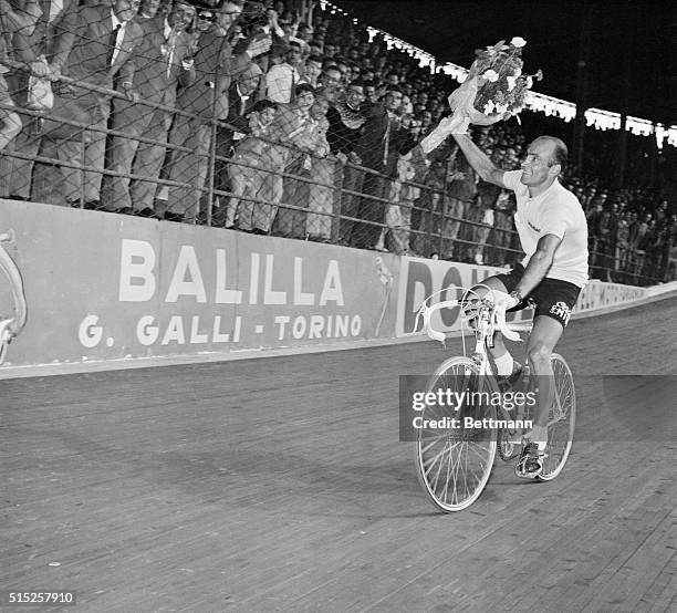 Wins Tour of Italy. Milan, Italy: Waving a bouquet at the cheering crowd, Italian veteran bicycle ace Fiorenzo Magni acknowledges the good wishes he...