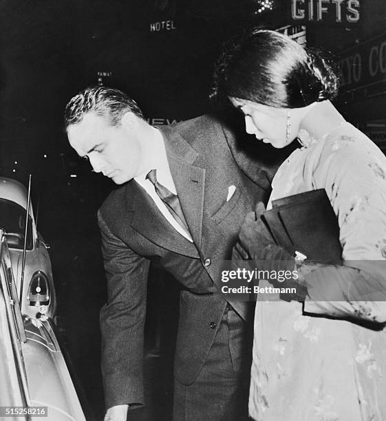 Actor Marlon Brando and his date, actress France Nuyen, prepare to enter Brando's car after newsmen discovered them during a midnight date at the new...
