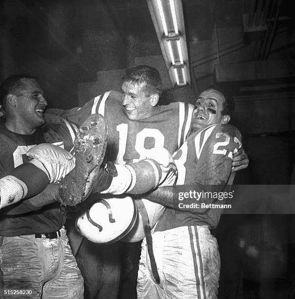 Teammates Steve Myhra and Carl Tasoff carry Baltimore quarterback Johnny Unitas into the dressing room after the Colts defeated the Giants 31-16 in...