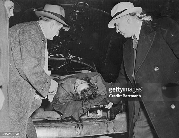 The body of Frank "The Enforcer" Nitti, is shown being removed from a squad car by two policemen, who are not identified. Nitti took his own life...