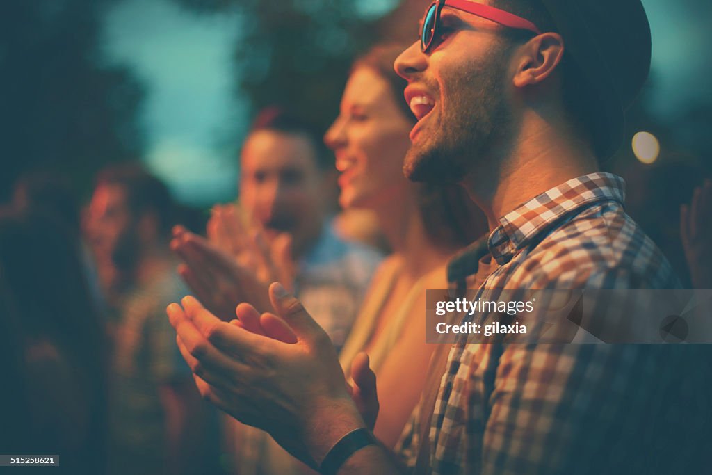 Fans clapping at concert.