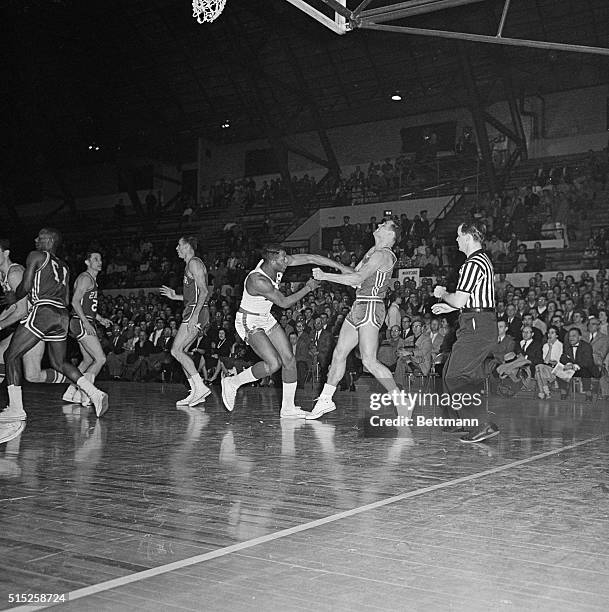 Elgin Baylor of the Minneapolis Lakers, takes a poke at Cliff Hagen, St. Louis Hawks, during the third game of the Western Division NBA playoffs here...