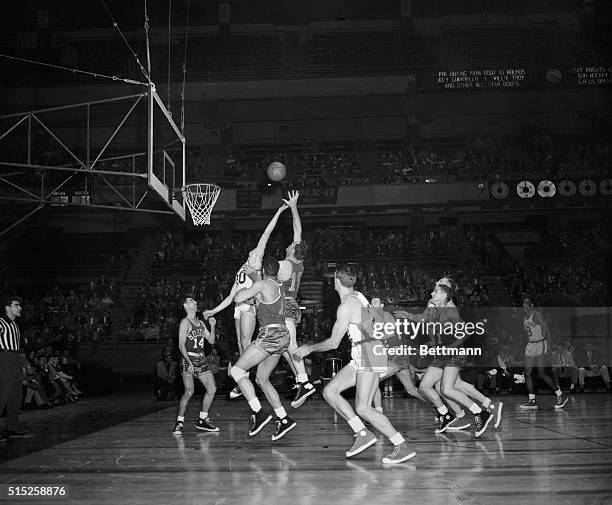 Jim Baechtold of the New York Knickerbockers and Bob Brannum of the Boston Celtics try to get a rebound in the first quarter of their professional...