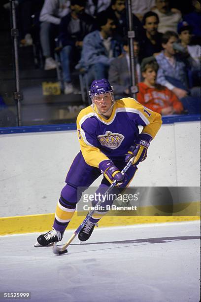 American ice hockey player Jimmy Carson, #17 for the Los Angeles Kings, skates up the ice with the puck in an away game against the New York...