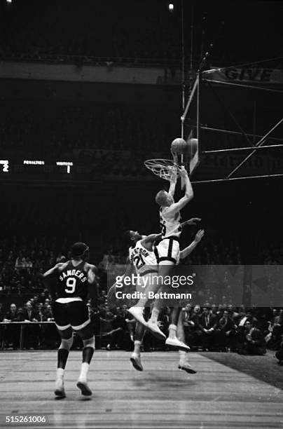 In a burst of over-enthusiasm, Darrell Imhoff, of the University of California, reaches through the hoop to snare the ball as Oscar Robertson , of...