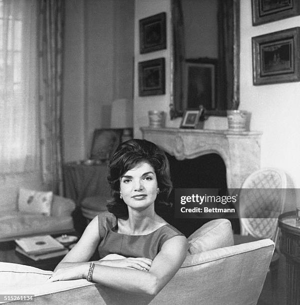 Undated photograph of Jacqueline Kennedy, seated, leaning on the back of a couch, circa 1960's.