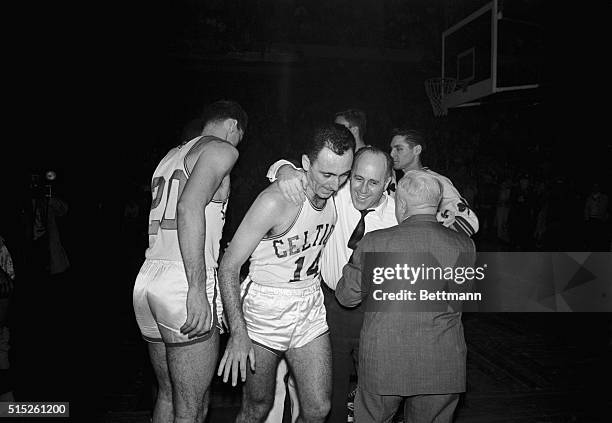 Boston Celtics coach "Red" Auerbach hugs his ace player, Bob Cousy , following the Celtics 122-103 victory over the St. Louis Hawks in the NBA...