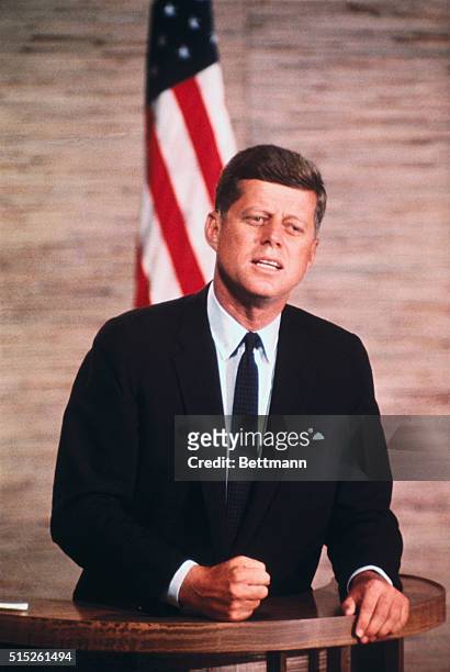 President John F. Kennedy addresses at the podium.