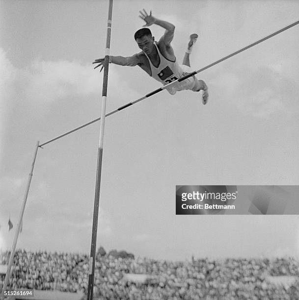 Taiwan's C.K. Yang sails over the bar in the pole vault event of the decathlon here, September 6th. Yang was first in the vault, clearing 14 feet, 1...