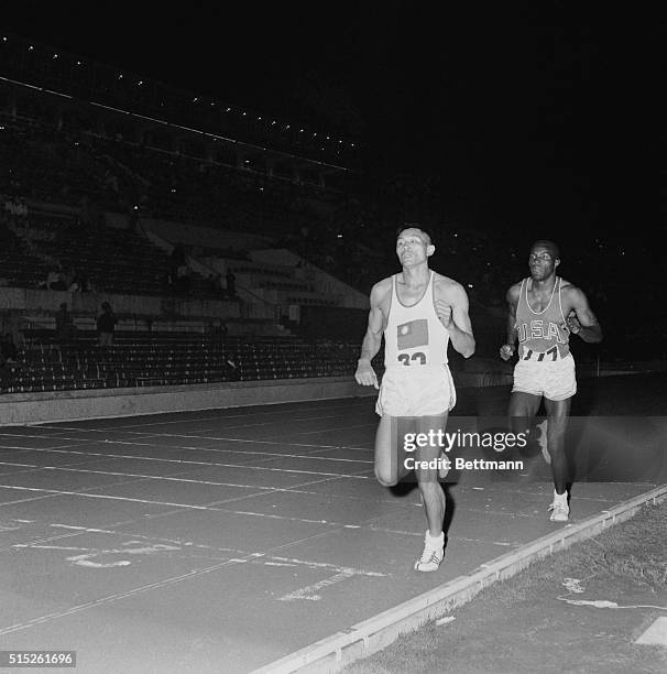 America's Rafer Johnson , Kingsbury, California, closely follows Formosa's C.K. Yang in the finish of the decathlon 1,500-meter run at the Olympic...