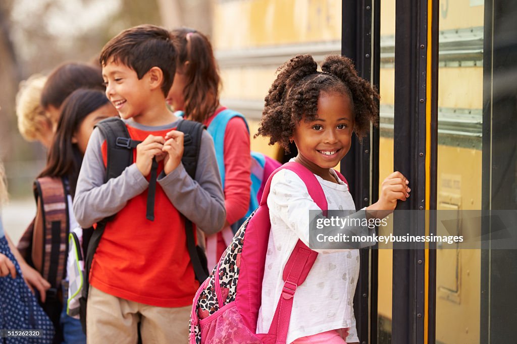 Elementary school girl at the front of the school bus queue