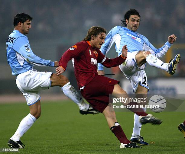 Roma's midfielder Francesco Totti kicks the ball despite Lazio Rome's midfielders Dejan Stankovic and Stefano Fiore during their Italian first league...