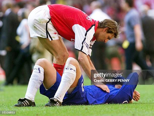 Arsenal's captain Tony Adams consoles Chelsea's Eidur GudJohnsen 04 May 2002 after Arsenal won the F.A. Cup, beating Chelsea 2-0 at The Millennium...