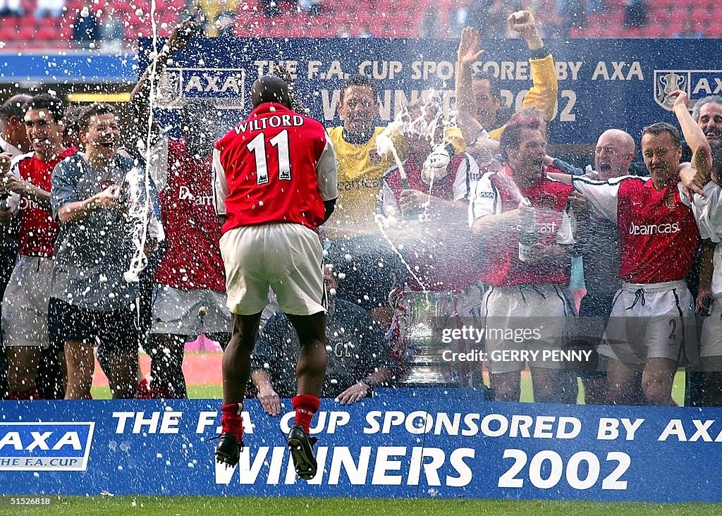 Arsenal's Sylvain Wiltord sprays his teammates 04