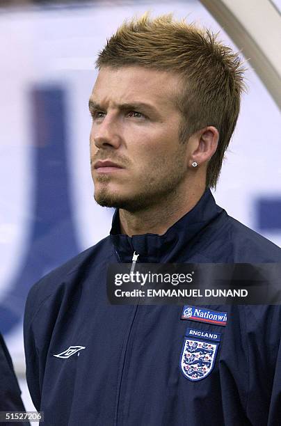Injured English player David Beckham listens to England's national anthem from the substitute bench 21 May 2002 during a pre-World Cup friendly match...