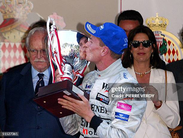 Scottish McLaren-Mercedes driver David Coulthard kisses his trophy in of front of Monaco's Prince Rainier III and Princess Caroline on the podium on...
