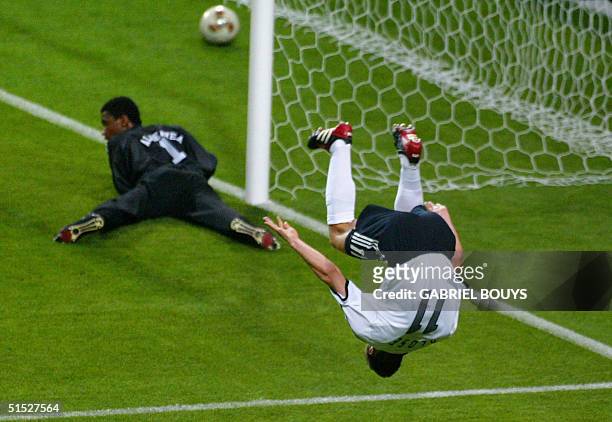 Germany's forward Miroslav Klose makes a flip after scoring the second goal as Saudi Arabia's goalie Mohammed Al Deayea at looks on at the Sapporo...