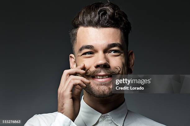 happy young man touching alrededor de los labios - bigote manillar fotografías e imágenes de stock