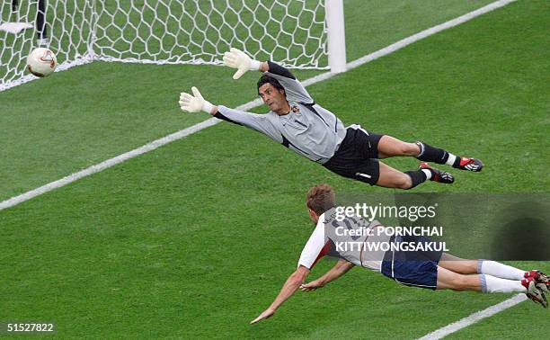 Forward Brian McBride puts a header past Portuguese goalkeeper Vitor Baia for his team's third goal in their Group D match at the 2002 FIFA World Cup...