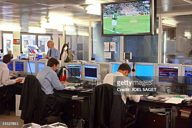 Screen shows the match between Germay and Ireland of the 2002 FIFA World Cup while brokers are at work in the "markets hall" of the Deutsche Bank 05...