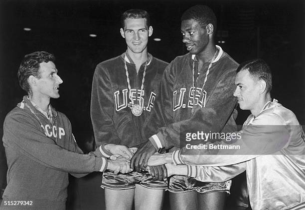 Jerry West and teammate Oscar Robertson , representing the U.S.A. Basketball players in the Rome Olympics, are congratulated by a representative from...