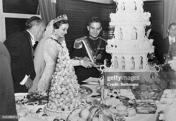 Photo shows Jordan's King Hussein with his new bride, Queen Dina, at a reception after their recent marriage. The new Queen cuts immense four layer...