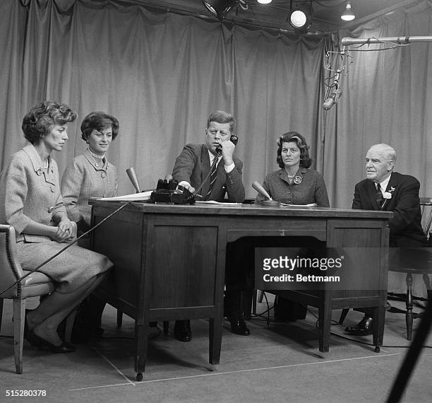 Surrounded by his three sisters and Governor Luther Hodges, presidential candidate John Kennedy receives a good luck phone call from his brother Bob...