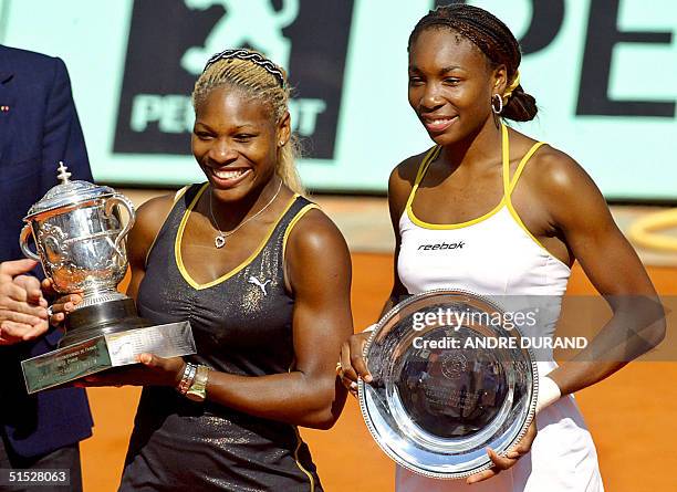 Serena Williams and her sister and opponent Venus Williams hold Roland Garros trophies, 08 June 2002 in Paris, at the end of the Roland Garros French...