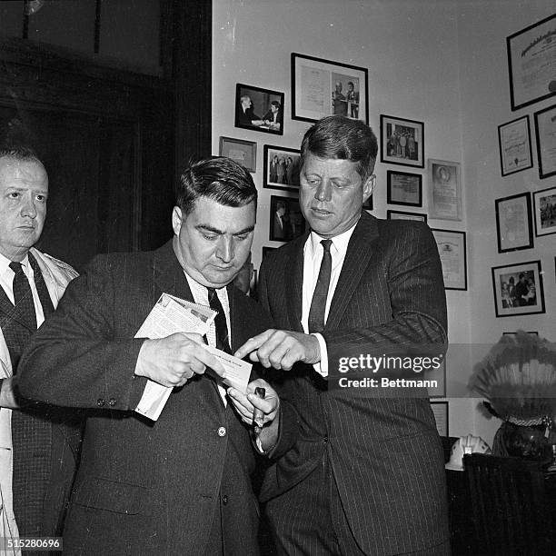 Washington, D.C......Back to work after a visit to wife and infant son at the hospital, President-Elect Kennedy confers with Press Secretary Pierre...