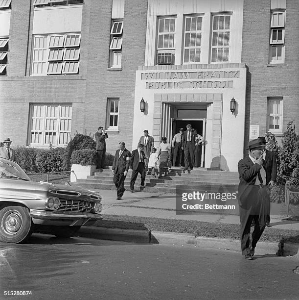 Police in front of William Frantz public school are shown, as an African American woman and child exit the building. The New Orleans schools were...