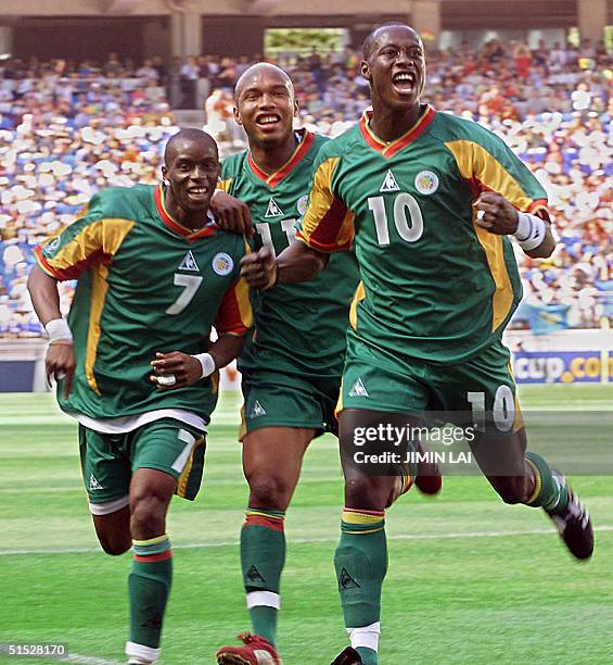 Senegalese defender Khalilou Fadiga celebrates his goal from a penalty kick with teammates Henri Camara and El Hadj Diouf in their Group A match...