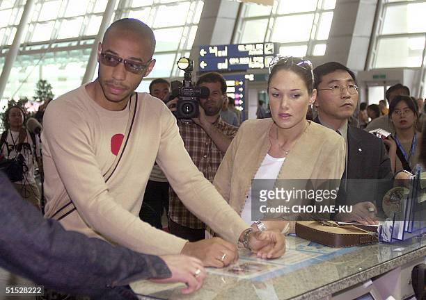 French national soccer team striker Thierry Henry and his girlfriend Claire arrive 12 June 2002 at Incheon airport, outside Seoul. Humiliated France...