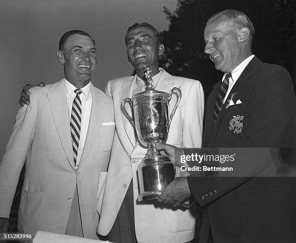 Issac Grainger, right, President of US Golf Association, is shown presenting winner's trophy to Ed Furgol, as last year's champ Ben Hogan stands by....