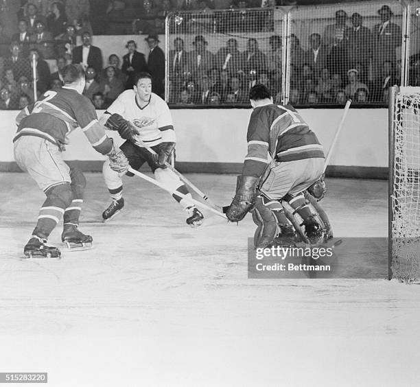 Slipping One Past Him. Detroit, Michigan: Marcel Pronovost of the Detroit Red Wings slips the puck past Montreal goalie Jacques Plante to score the...