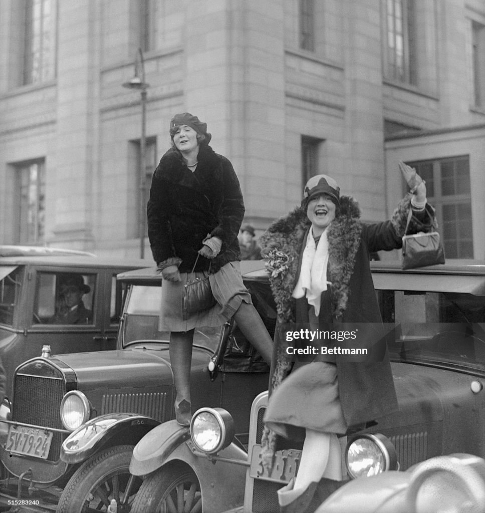Flappers Standing on Car Hoods
