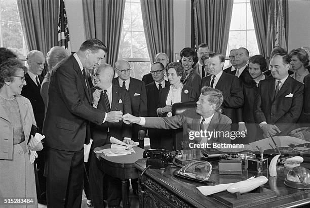 President Kennedy gives one of the pens he used to sign a bill granting a charter to the Eleanor Roosevelt Foundation to Assistant Secretary of...