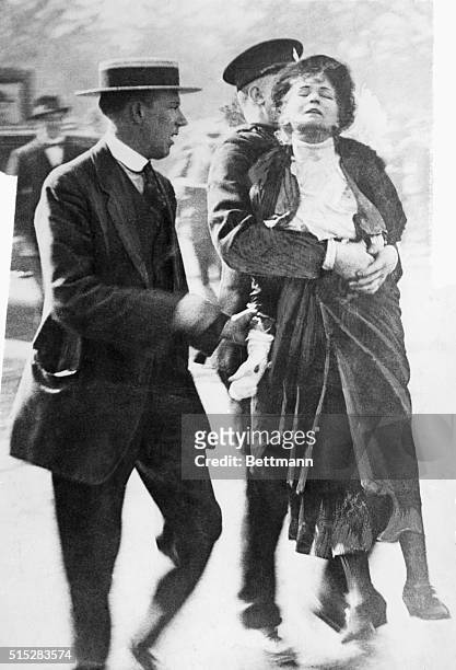 Emmeline Pankhurst is led away by a policeman after leading a group of suffragettes in an attempt to present a petition to the King at Buckingham...