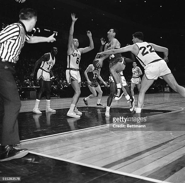 Playmaker Bob Cousy, playing his final game in Madison Square garden here march 3rd, goes in for a layup guarded by the New York Knickerbockers' Tom...