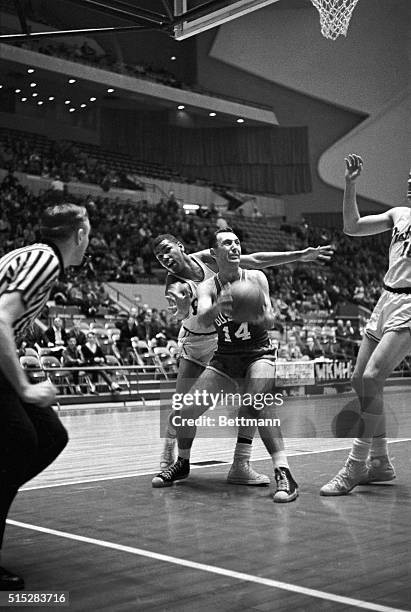 Piston Ray Scott tries vainly to get at the ball as Boston's Bob Cousy prepares to shoot during the second period of the Detroit Pistons-Boston...