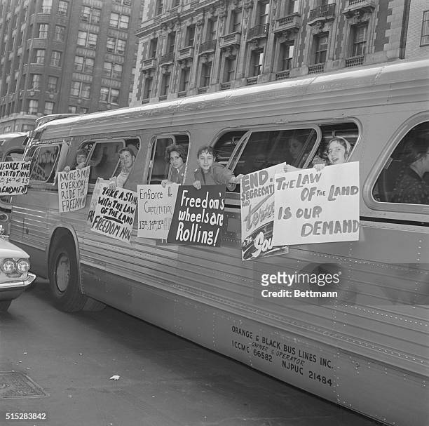 Freedom Group Hangs Signs on Bus. New York: Members of a group called "The Washington Freedom Riders Committee" hang signs on the side of bus parked...