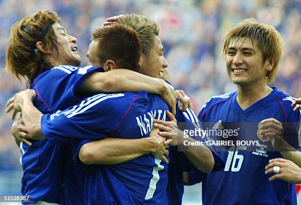 Japan's midfielder Hidetoshi Nakata is hugged by teammates after scoring the second goal against Tunisia during match 45 group H of the 2002 FIFA...