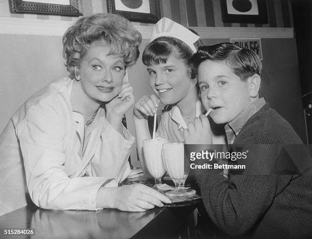 Comedienne Lucille Ball takes a break on a Hollywood TV film set to play hostess to her own youngsters at a movie "soda fountain." Daughter Lucie...
