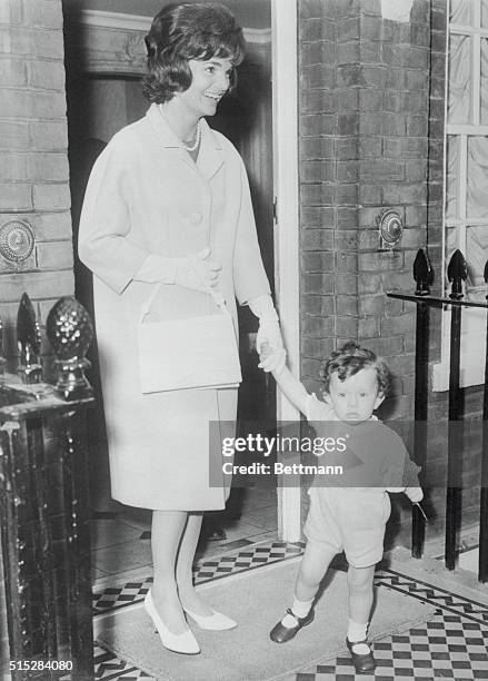 America's First lady, Mrs. Jacqueline Kennedy, holds her three-year-old nephew, Anthony, by the hand as they leave the residence of her sister,...
