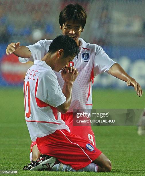 Korea's Lee Young Pyo gets down on his knees as teammate Seol Ki Hyeon joins to celebrate, 14 June 2002 at the Incheon Munhak Stadium in Incheon,...